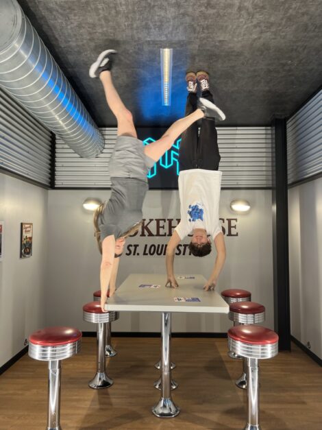 A woman and teen appearing to be standing on the ceiling upside down over a diner table.