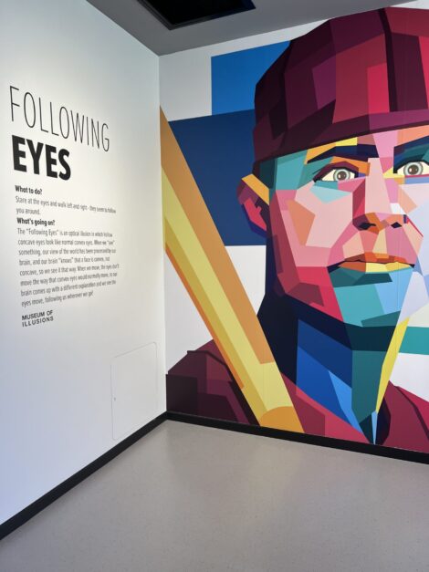 Signage explains the background of the illusion of a baseball player's eyes following those who walk by. 