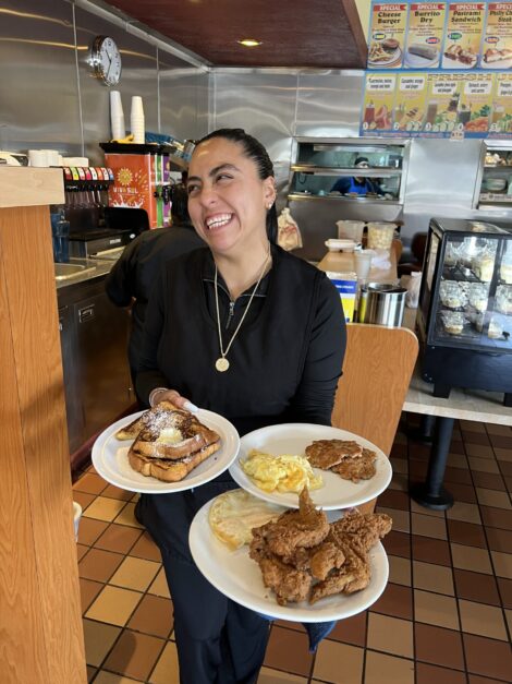 Waitress serving breakfast at CJ's Cafe